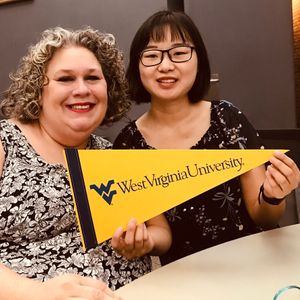 Susan Lantz with a student holding a WVU pennant