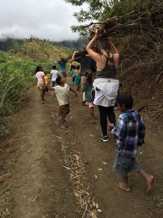 Students and Timor-Leste children carrying firewood