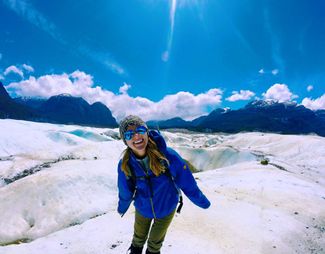 A student smiling standing on glaciers