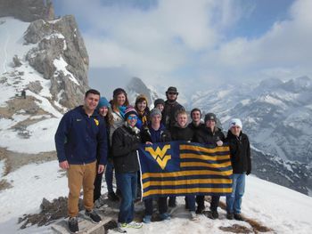 Group holding WVU flag in mountains